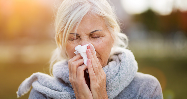 Woman sneezes